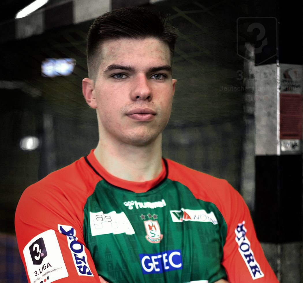 Porträt des Handballspielers Renārs Uščins im grün-roten Trikot des SC Magdeburg.