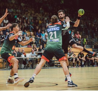 Defensive Aktion im DHB-Pokal: Kreisläufer Erik Schmidt (Nummer 21) und ein weiterer SCM-Spieler verteidigen konzentriert den eigenen Kreis gegen den Northeimer HC.