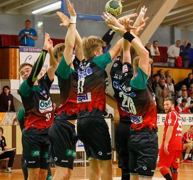 Vier Handballer der SC Magdeburg Youngsters bilden einen geschlossenen Abwehrblock gegen einen gegnerischen Sprungwurf.