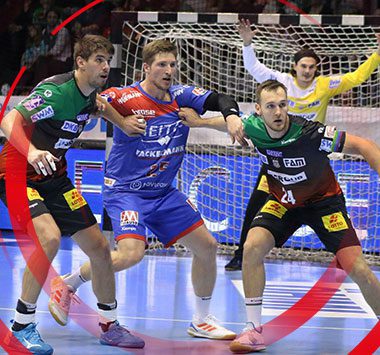 Handball-Actionaufnahme: SC-Magdeburg-Spieler (darunter Sulli, Piotr und Jannick) im Zweikampf mit Gegenspielern um den Ball, einer der Magdeburger in grünem Trikot im Vordergrund.