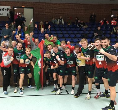Jubelnde SCM-YoungsterS nach dem 10-Tore-Sieg bei DHK Flensburg: Die Spieler posieren gemeinsam für ein Siegerfoto in der Halle.
