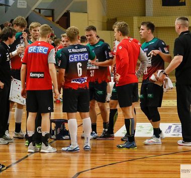 Die Mannschaft der SCM Youngsters versammelt sich beim Vorbericht zum Spiel gegen die SG Flensburg-Handewitt in einer Besprechung auf dem Spielfeld.