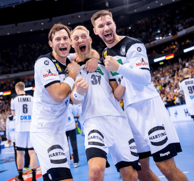 Die deutschen Nationalspieler Martin Strobel, Matthias Musche, Uwe Gensheimer und Patrick Wiencek jubeln gemeinsam im weißen DHB-Trikot während der Weltmeisterschaft.