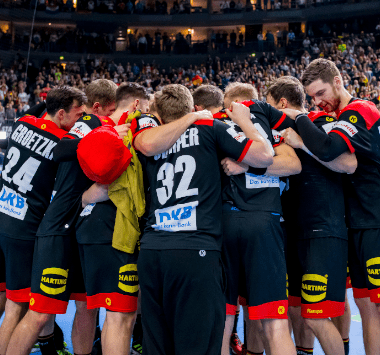 Emotionaler Teamjubel der deutschen Handball-Nationalmannschaft auf dem Spielfeld.