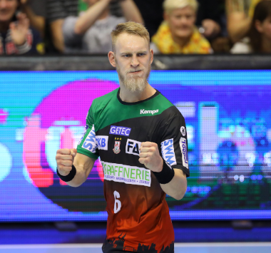 SCM-Handballspieler Matthias Musche blickt mit geballten Fäusten und fokussiertem Blick nach vorne.