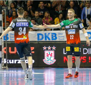 Die SCM-Handballspieler Michael Damgaard und Lukas Mertens klatschen sich während des Spiels gegen die Eulen Ludwigshafen ab.