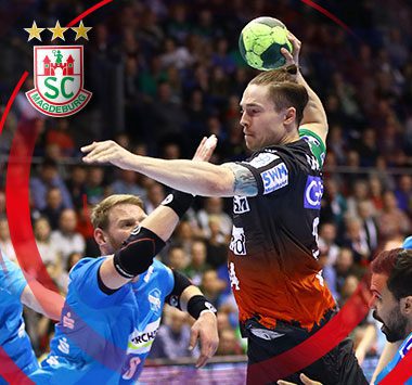 SCM-Handballspieler Michael Damgaard setzt im grün-roten Trikot in der Luft zu einem kraftvollen Sprungwurf an.