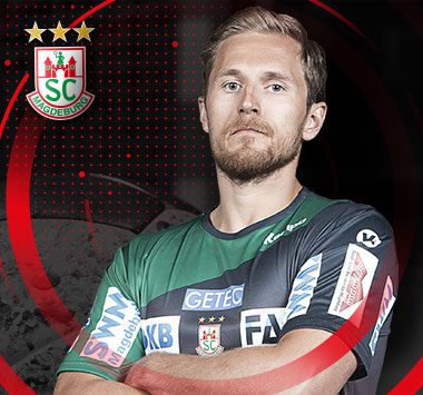 Porträt von SCM-Handballspieler Albin Lagergren im grünen Trikot mit verschränkten Armen.