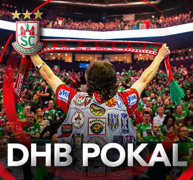 SC Magdeburg Mannschaftsarbeiter Sascha Klahn von hinten, der jubelnd einen Fanschal vor der Fankurve hochhält, mit dem Schriftzug „DHB POKAL“.