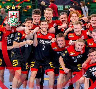Junge Nachwuchsspieler des deutschen Nationalteams (DHB) jubeln gemeinsam in ihren roten und schwarzen Trikots auf dem Spielfeld.