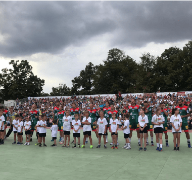 Die Mannschaften des SC Magdeburg und des SC DHfK Leipzig laufen gemeinsam mit Einlaufkindern beim Open-Air-Event in Aschersleben auf.