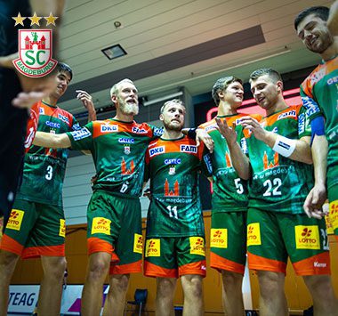 Jubelnde Handballer des SC Magdeburg auf dem Spielfeld.