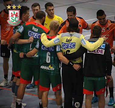 Die Mannschaft des SC Magdeburg steht in einem engen Teamkreis eng zusammengestellt auf dem Spielfeld, um sich taktisch abzustimmen.