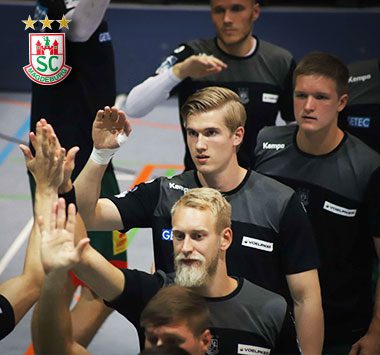 Spieler des SC Magdeburg klatschen am Spielfeldrand ab.