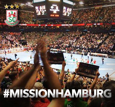 Werbebanner „#MISSIONHAMBURG“ mit jubelnden Fans in einer Handball-Arena.