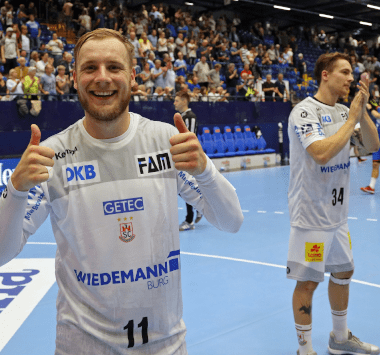 Daniel Pettersson vom SC Magdeburg zeigt lächelnd die Daumen nach oben.