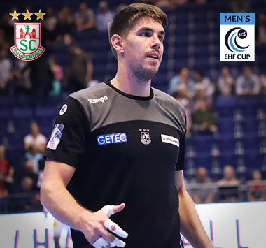 Handballspieler Piotr Chrapkowski blickt im schwarzen EHF-Cup-Trikot des SC Magdeburg fokussiert zur Seite.