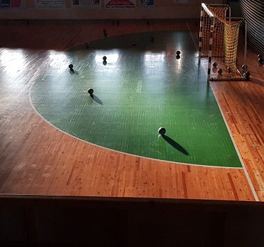 Blick von oben auf das leere Handballspielfeld mit Holzboden und grünem Torraum vor einem Heimspiel der SCM YoungsterS.