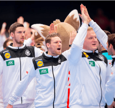 Spieler der deutschen Handball-Nationalmannschaft klatschen gemeinsam ab.