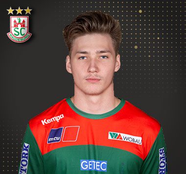 Porträt: Paul Schikora blickt im offiziellen grünen Trikot des SC Magdeburg frontal in die Kamera.