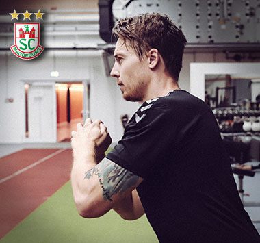 Krafttraining: Michael Damgaard (SC Magdeburg) blickt im schwarzen Trainingsshirt fokussiert von der Seite in den Trainingsraum.