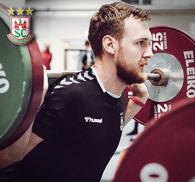 Krafttraining: Christian O'Sullivan (SC Magdeburg) absolviert fokussiert Kniebeugen mit einer schwer beladenen Langhantel auf den Schultern.