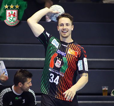 SCM-Handballer Michael „Mika“ Damgaard (Nr. 34) lächelnd mit einem Handball in der Hand.