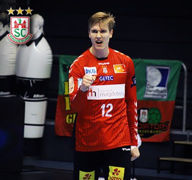 Torwartporträt am Spielfeldrand: SCM-Torhüter Tobias Thulin steht im roten Torwarttrikot mit der Nummer 12 und weit geöffnetem Mund aufmerksam in der Halle.