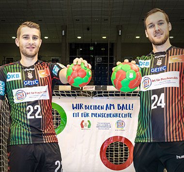 SCM-Spieler Lukas Mertens und Christian O'Sullivan auf einer Aktionsgrafik für Menschenrechte.