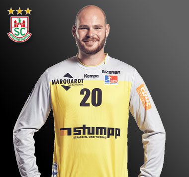 Torwartporträt: Torhüter Mike Jensen blickt im gelb-grauen Kempa-Trikot mit der Rückennummer 20 lächelnd nach vorne.