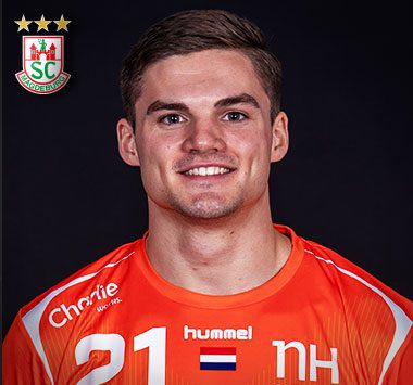 Spielerporträt: Rückraumspieler Kay Smits blickt im orangen Nationaltrikot der Niederlande (Rückennummer 21) lächelnd frontal in die Kamera.