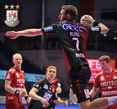 Justus Kluge (Nummer 7) vom SC Magdeburg wirft im Sprungwurf den Handball auf das Tor.