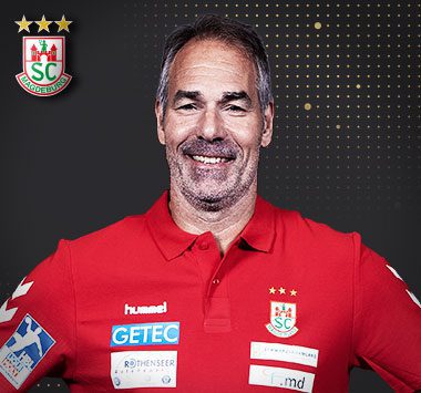 Porträtfoto von Tomas Svensson im roten Vereinstrikot des SC Magdeburg mit SCM-Logo oben links.
