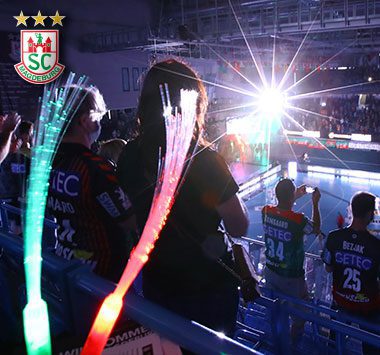 SC Magdeburg-Fans mit Leuchtstäben in der Arena.