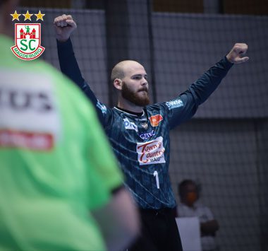 Mike Jensen feiert jubelnd eine Parade des SC Magdeburg.