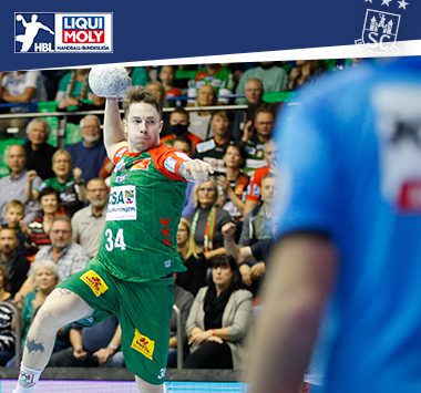 Michael Damgaard holt im grün-roten Trikot des SC Magdeburg zum kraftvollen Sprungwurf aus.