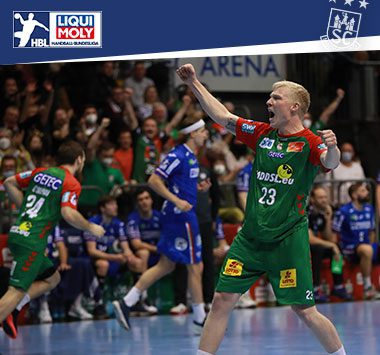 Magnus Saugstrup jubelt im grün-roten Trikot des SC Magdeburg mit erhobenen Armen auf dem Spielfeld.