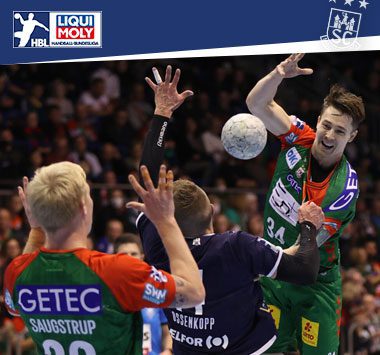 Michael Damgaard wirft im grün-roten Trikot des SC Magdeburg den Ball über die gegnerische Abwehr