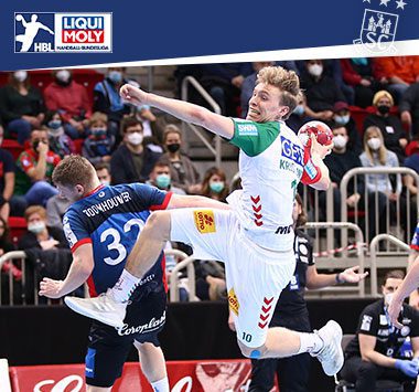 Gisli Kristjánsson springt im weißen Trikot des SC Magdeburg zum Torwurf gegen eine Abwehr.