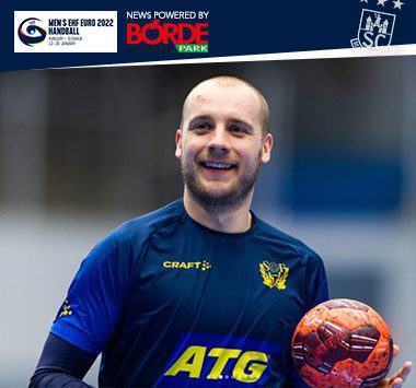 Daniel Pettersson blickt im blau-gelben schwedischen Nationaltrikot lächelnd nach vorne und hält einen Handball.