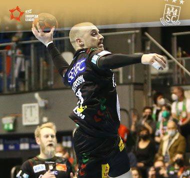 Daniel Pettersson holt im schwarzen Trikot des SC Magdeburg im Sprung zum Torwurf aus.