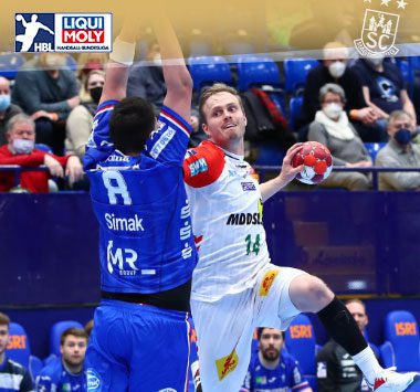 Ómar Ingi Magnússon zieht im weißen Trikot des SC Magdeburg zum Torwurf gegen die Abwehr des TBV Lemgo Lippe.