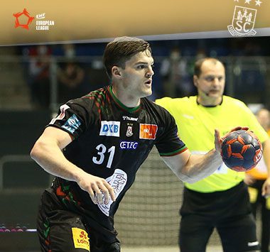 Kay Smits läuft im schwarzen Trikot des SC Magdeburg mit dem Handball in der Hand zum Angriff an.