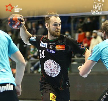 Christian O'Sullivan blickt im schwarzen Trikot des SC Magdeburg mit dem Handball in der Hand fokussiert nach vorne.