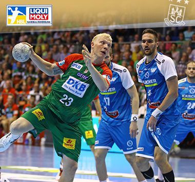 Magnus Saugstrup springt im grün-roten Trikot des SC Magdeburg zum Torwurf gegen die Stuttgarter Abwehr.