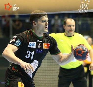 Kay Smits blickt im schwarzen Trikot des SC Magdeburg mit dem Handball in der Hand nach vorne.