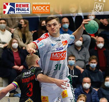 Kay Smits holt im weiß-grauen Trikot des SC Magdeburg zum Wurf aus.