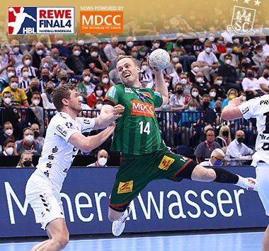 Ómar Ingi Magnússon zieht im grün-roten Trikot des SC Magdeburg im Sprungwurf gegen die Kieler Abwehr ab.