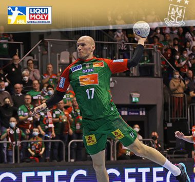 Tim Hornke springt im grün-roten Trikot des SC Magdeburg zum Torwurf.