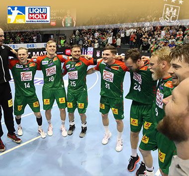 Die Spieler des SC Magdeburg jubeln gemeinsam im Kreis auf dem Handballfeld.